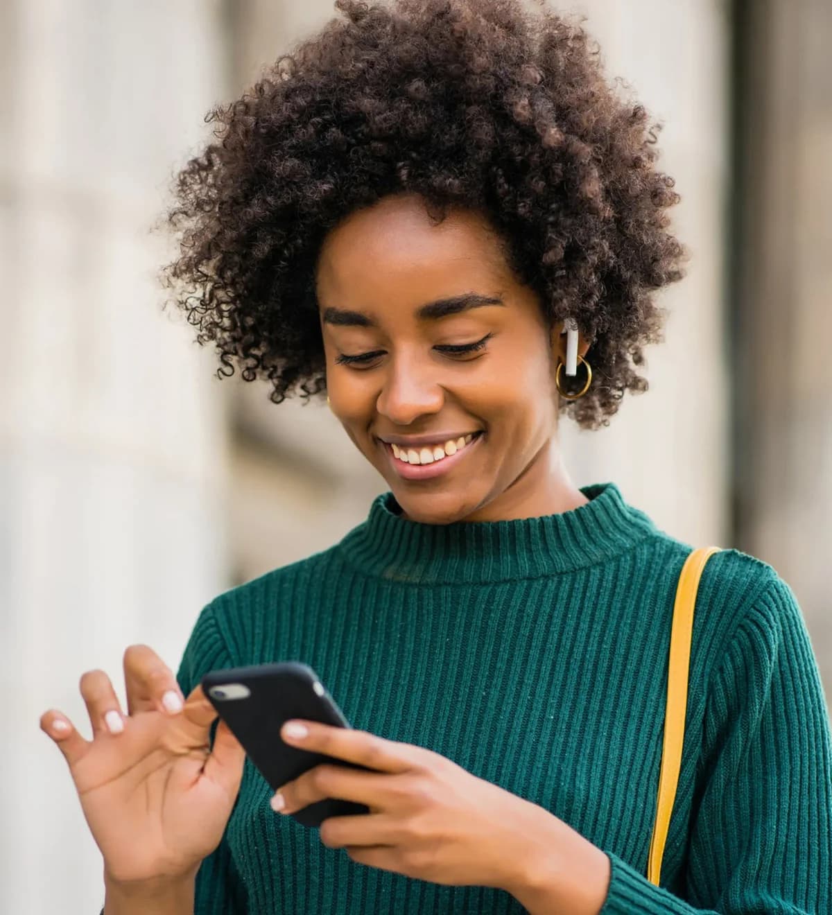 A young Nigerian woman checking property listings on her phone